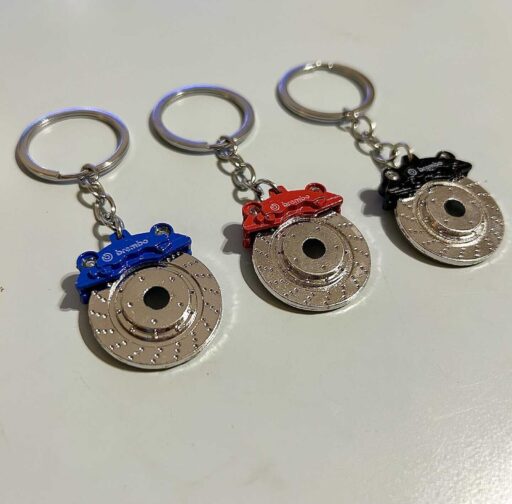 Brembo brake rotor keychains in red, blue, and black colors, showcasing automotive performance accessories, ideal for car enthusiasts and motorsport fans.