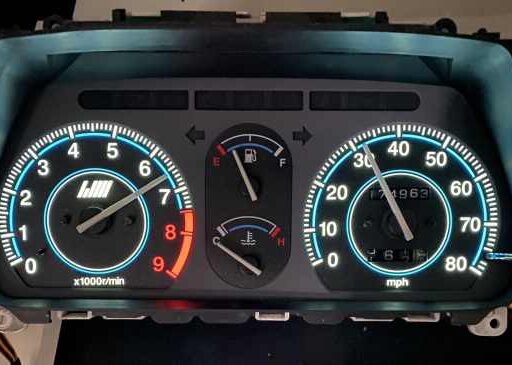 High-performance vehicle dashboard gauge cluster showing tachometer, speedometer, and fuel gauges with LED lighting. Perfect for automotive enthusiasts and performance tuning.