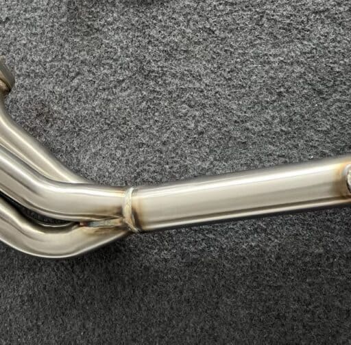 High-performance stainless steel exhaust header for improved power and efficiency, designed for optimal engine performance and durability. Perfect for racing and custom car builds.