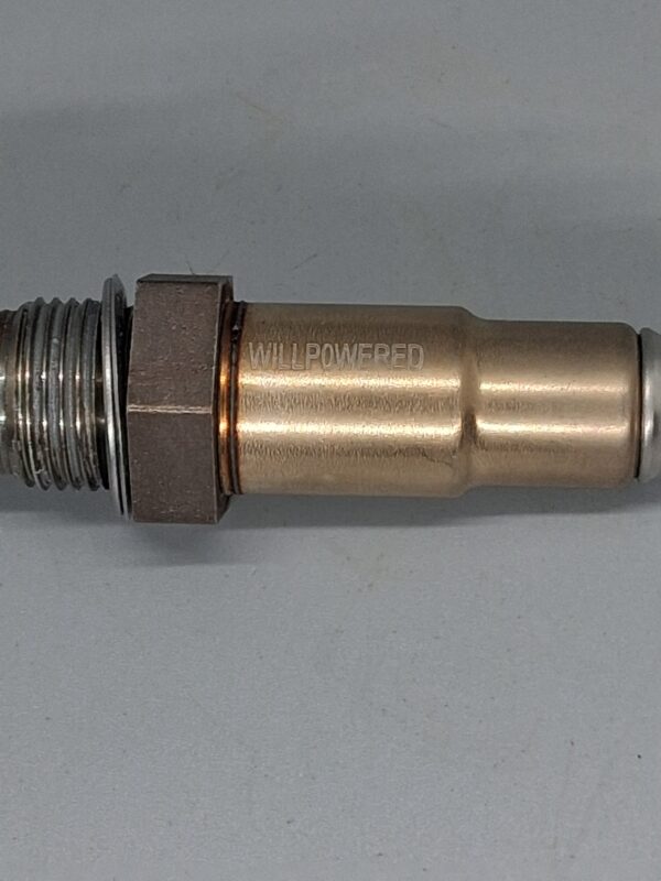 A close-up of a Willpowered Performance spark plug showing high-quality metal construction, designed for enhanced vehicle performance and reliability.