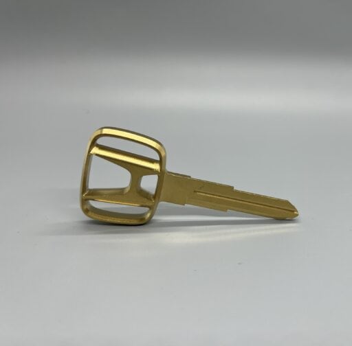 Close-up of a gold billet Honda Acty key with a sleek design, ideal for custom vehicle keys and accessories.